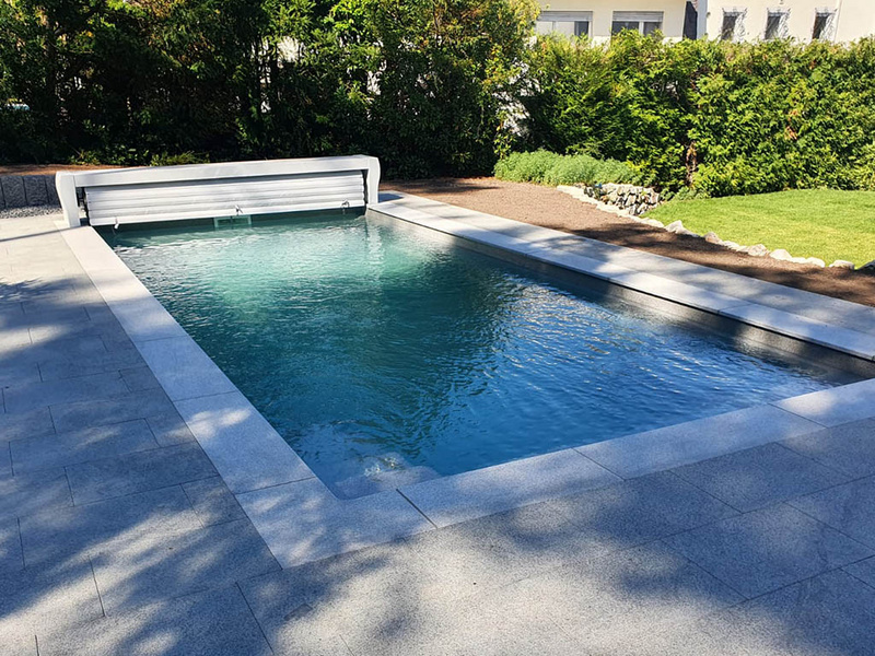 Pool mit Poolrandplatten und Plattenbelag aus Granit