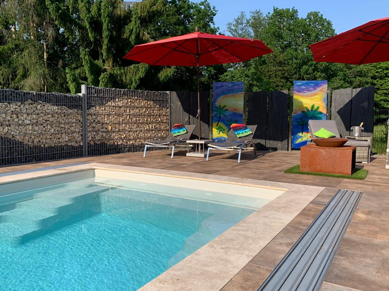Pool mit Randeifassung aus Travertin und großformatigen Keramikplatten