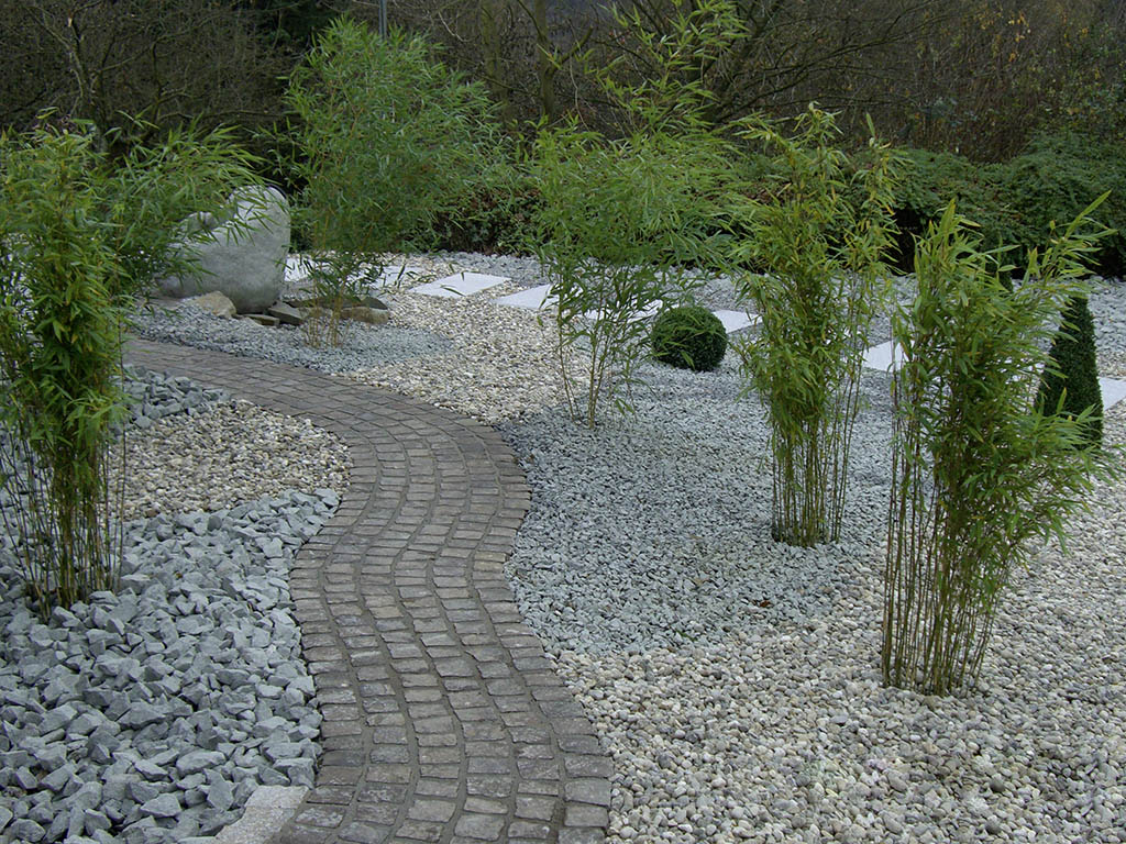 Natursteinpflasterung durch Bambusgarten 