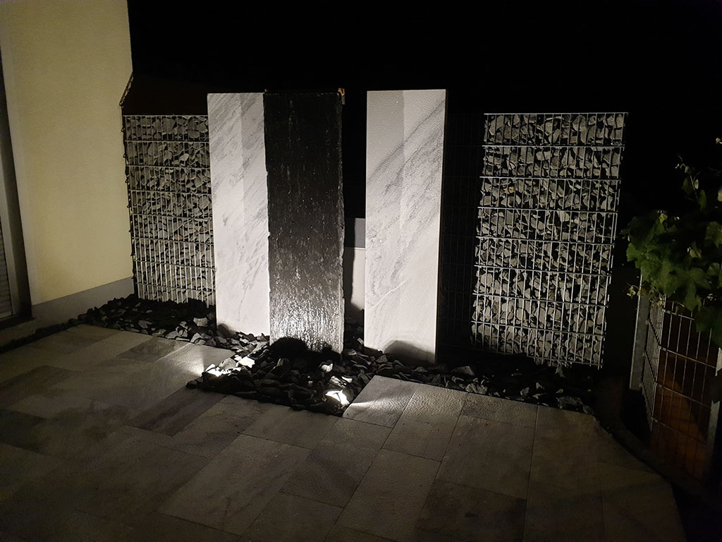 Natursteinwasserwand mit Beleuchtung und Sichtschutz