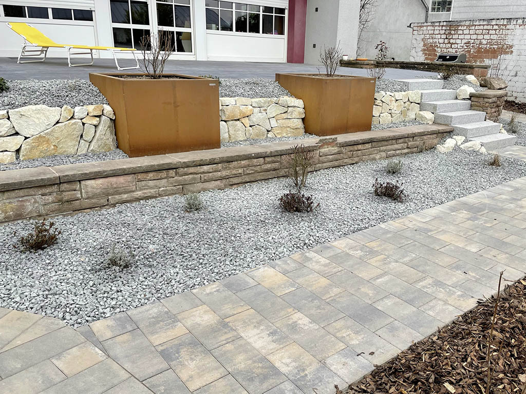 Trockenmauer mit Cortenstahlkübeln 