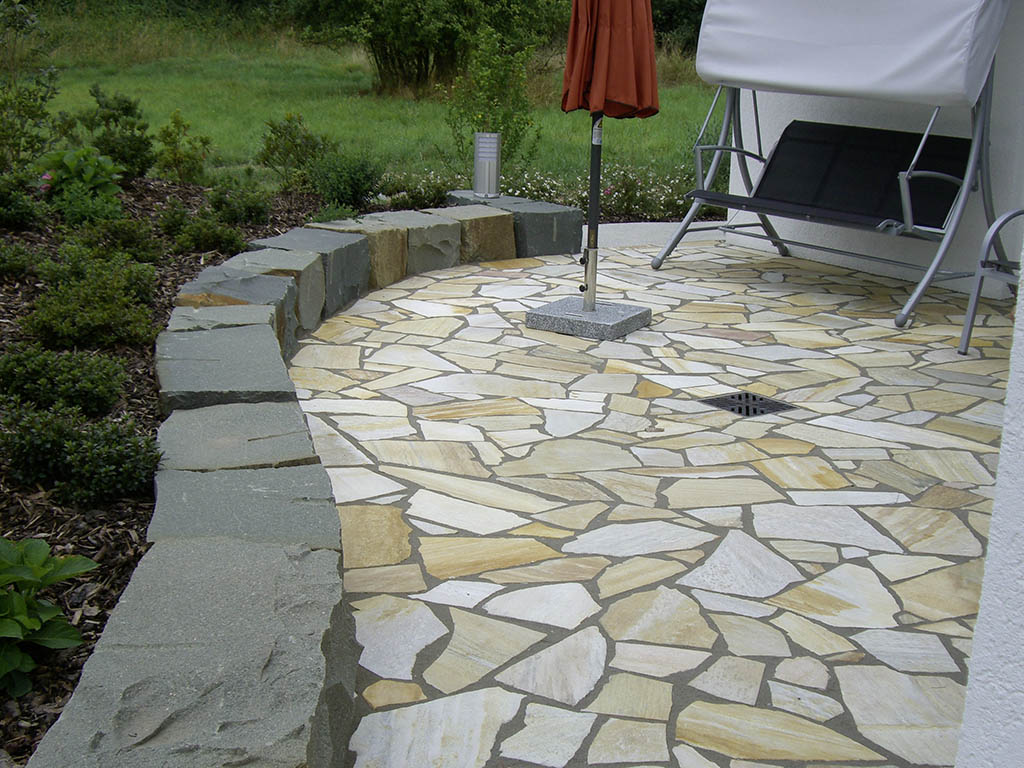 Polygonalplatten mit Einfassung aus Natursteinblöcken 