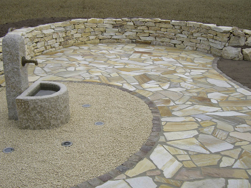 Polygonalplatten, Natursteinmauer und Brunnen 