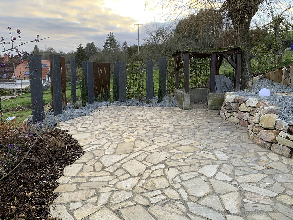 Polygonalplatten mit Natursteinmauer