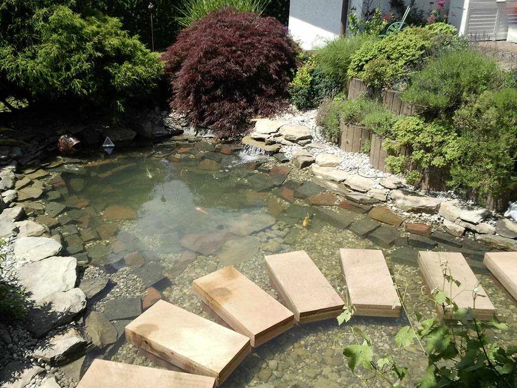 Gartenteich mit Brücke aus Schrittsteinen 